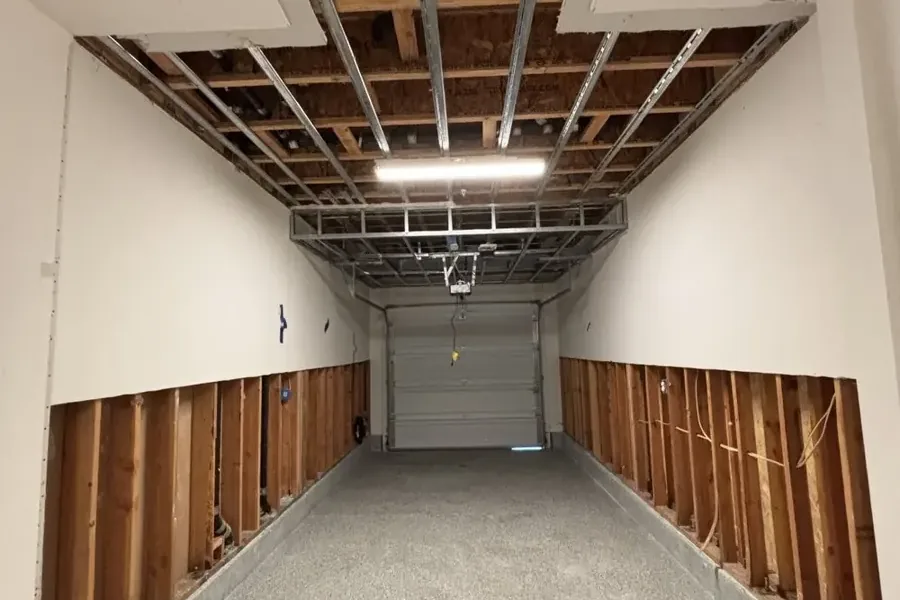 Room with lower wallboard removed and exposed ceiling framing